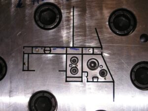 Detailní pohled na precizní řez ocelového bloku pomocí drátové elektroeroze (Wire EDM).