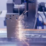 Elektroerozivní drátová řezačka vyřezávající tvar ozubeného kola do střižné vložky, průmysl CNC strojů.